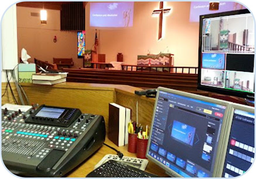 A church with a large screen and two computers.