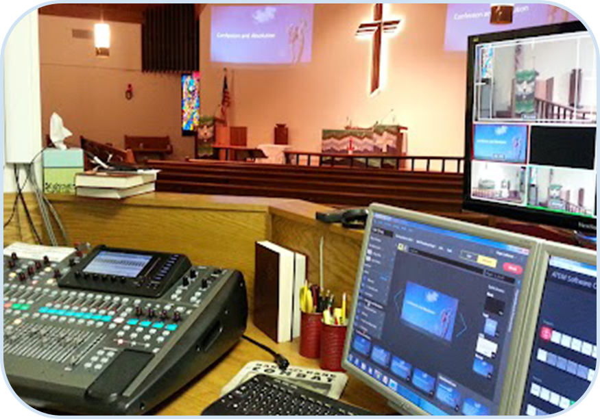 A church with a large screen and two computers.