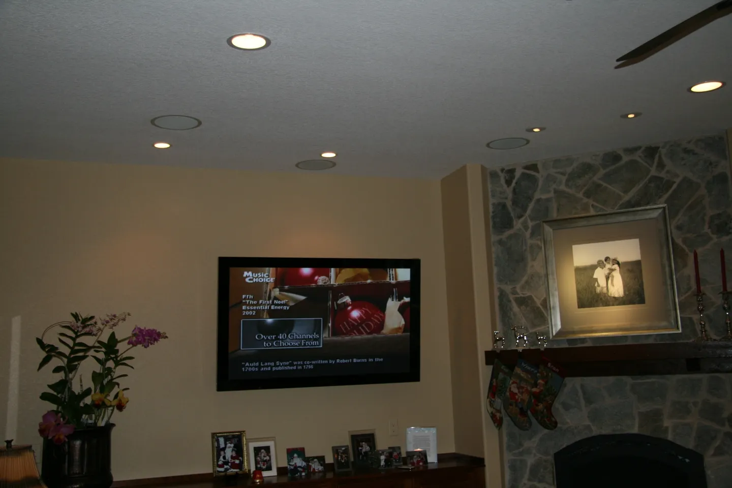 A television mounted on the wall above a fireplace.