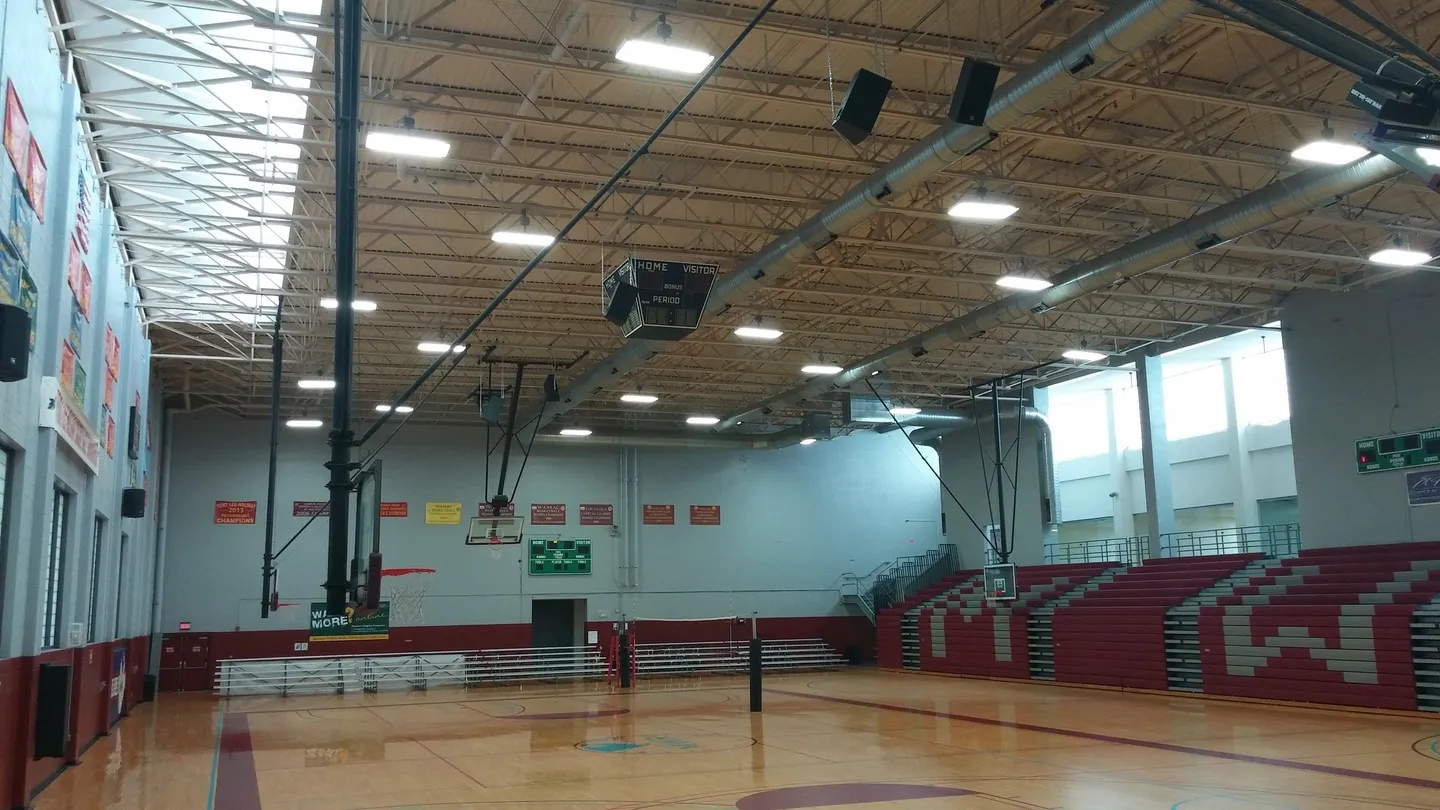 A gym with basketball court and bleachers.