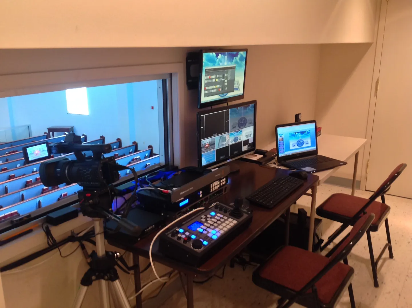 A room with several monitors and laptops on the table.