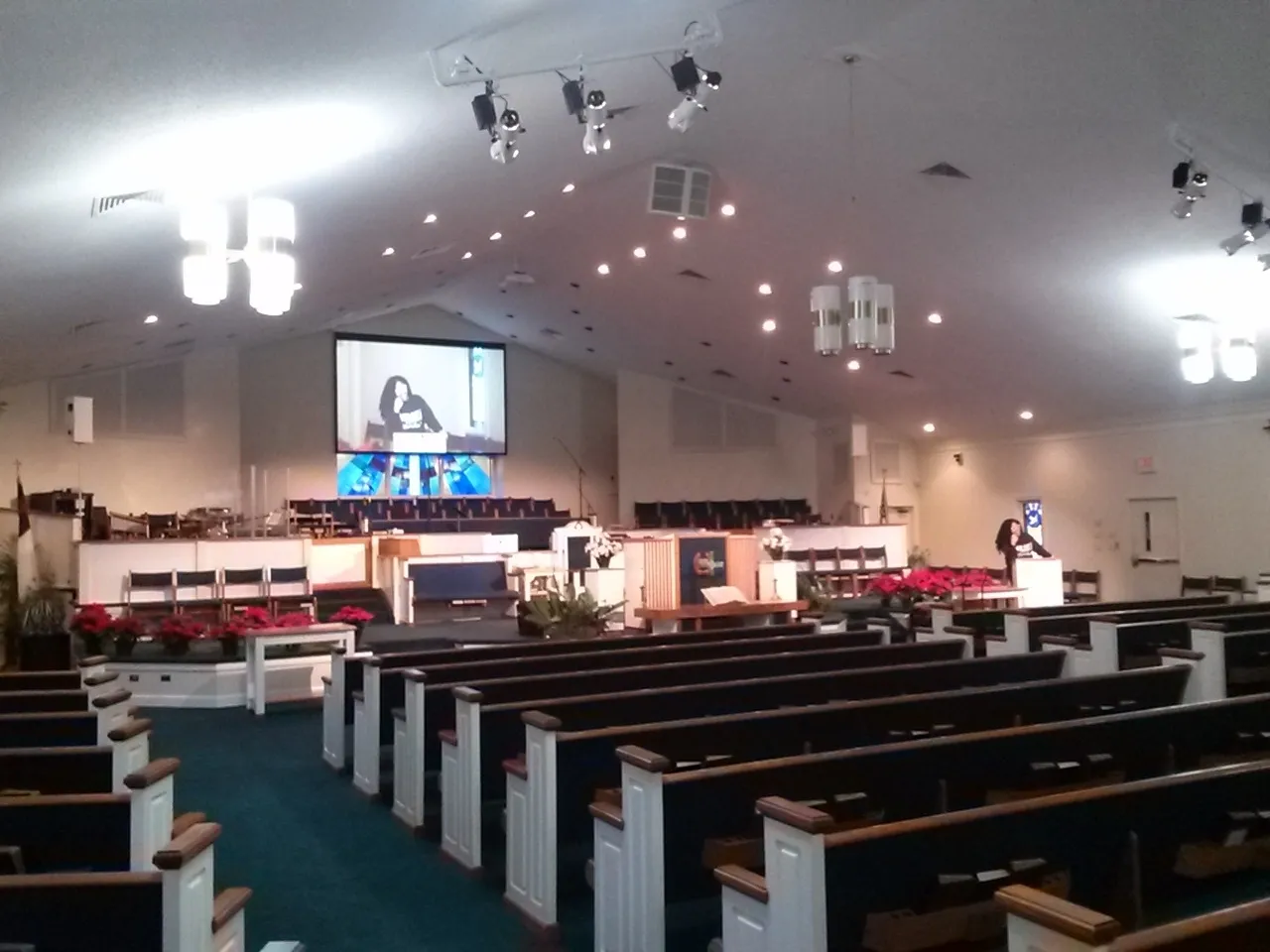 A large church with many pews and a big screen