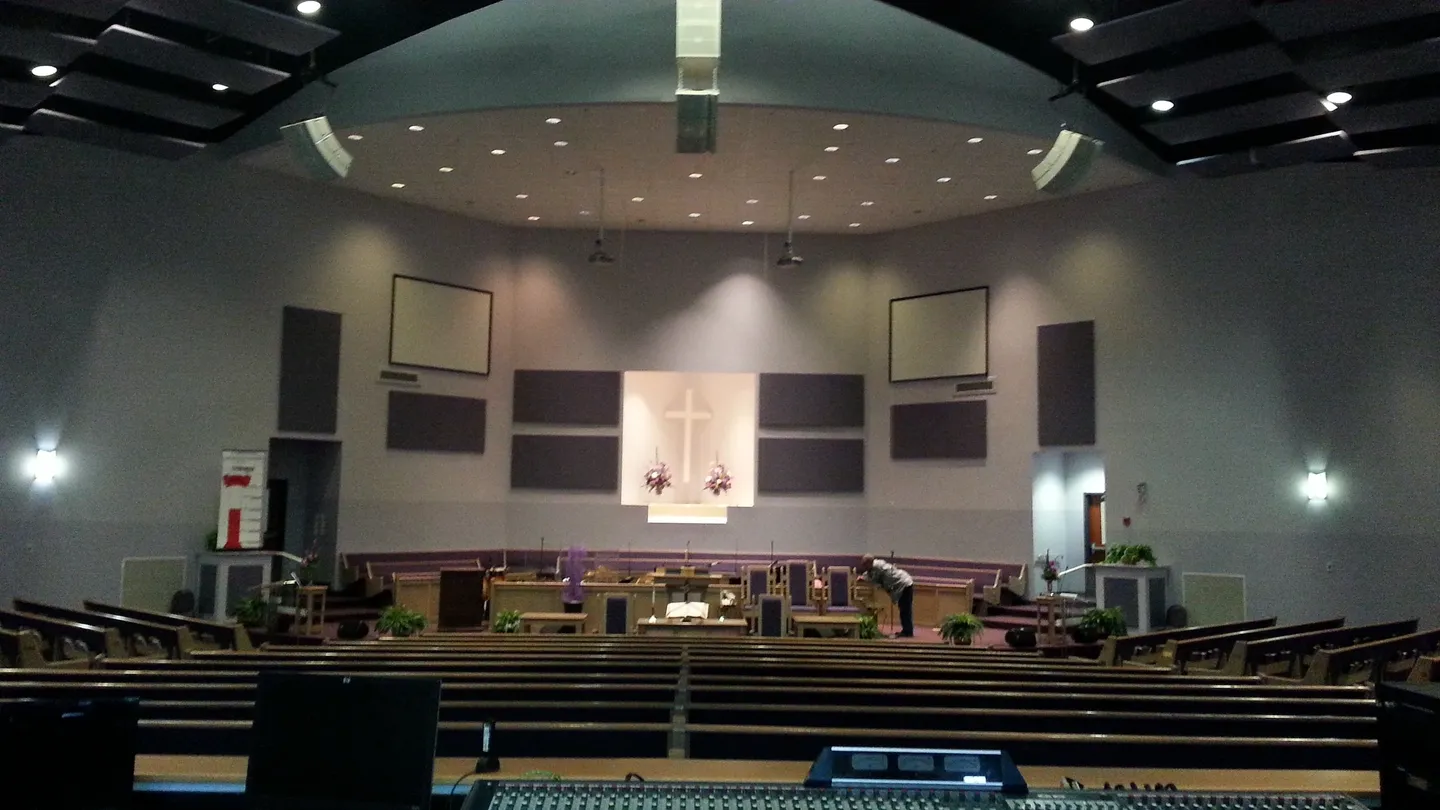 A large church with many seats and a big screen