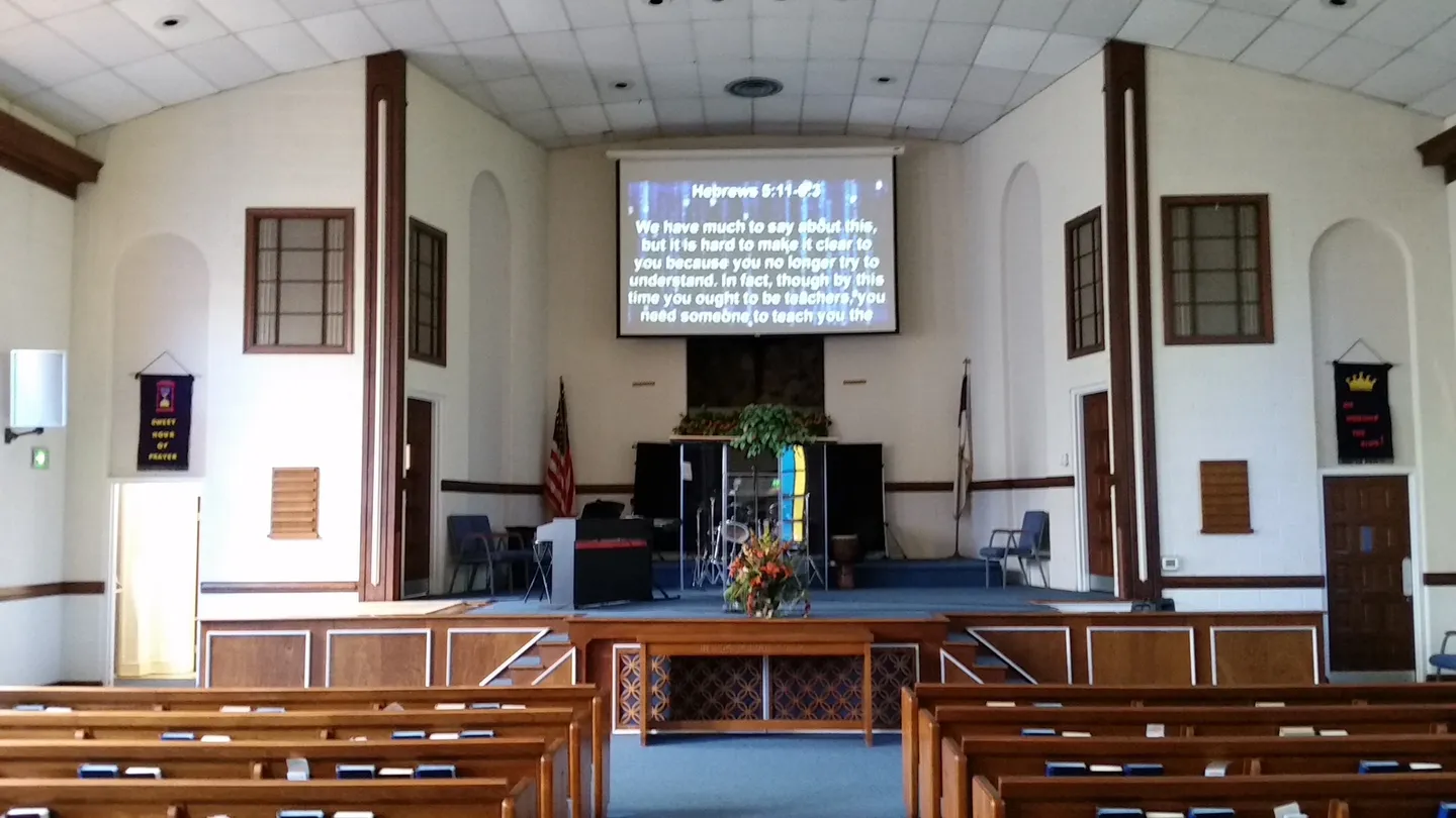 A church with a large screen and many pews