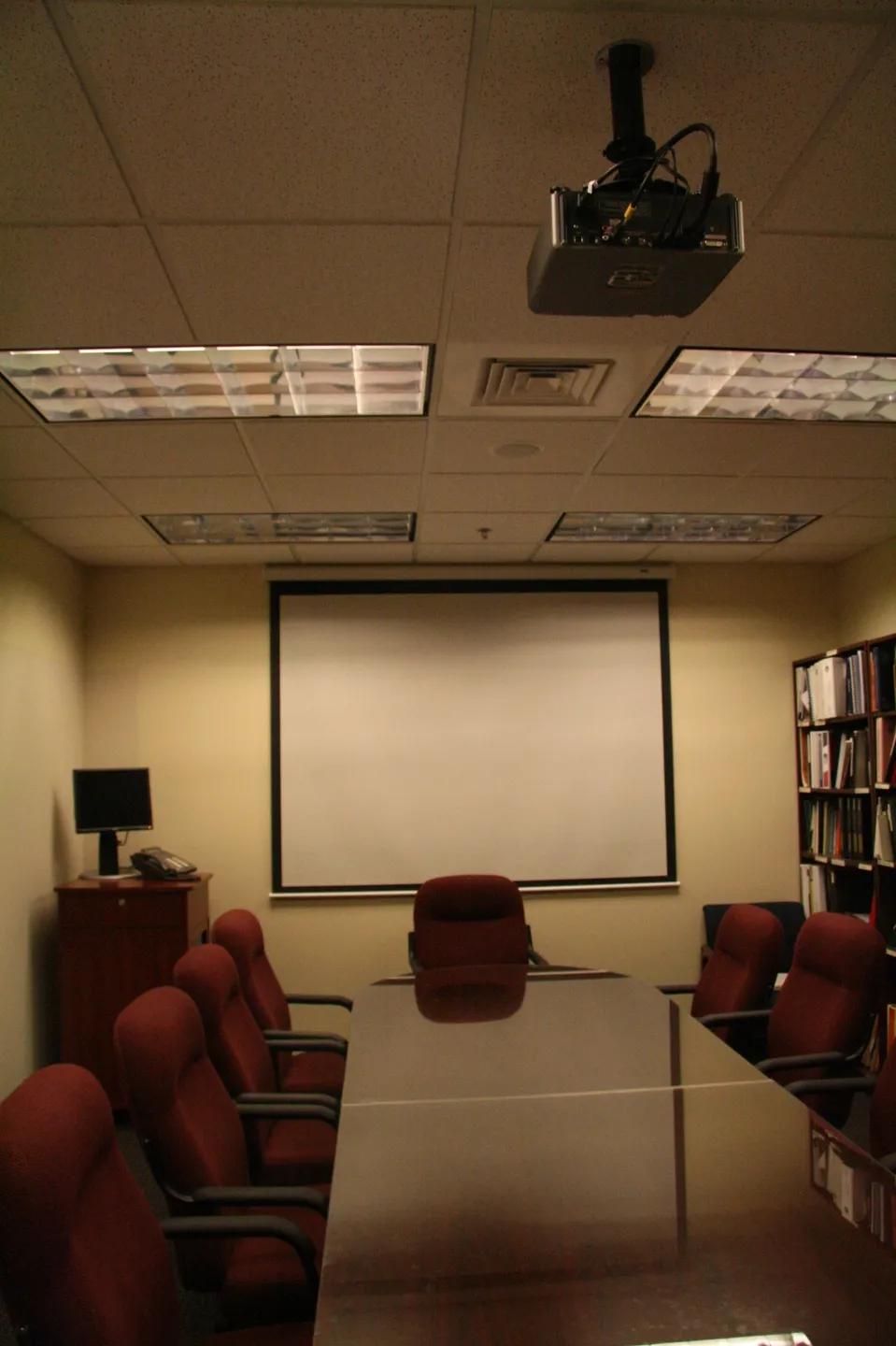 A conference room with a projector and screen
