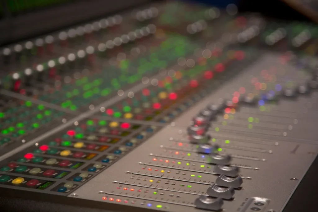 A close up of the side of an audio mixing board.