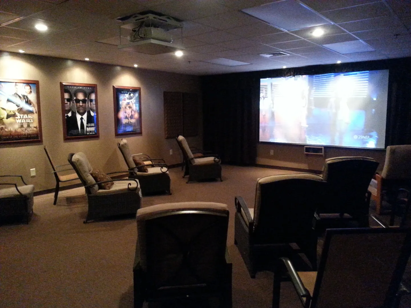 A room with several chairs and a projector screen.