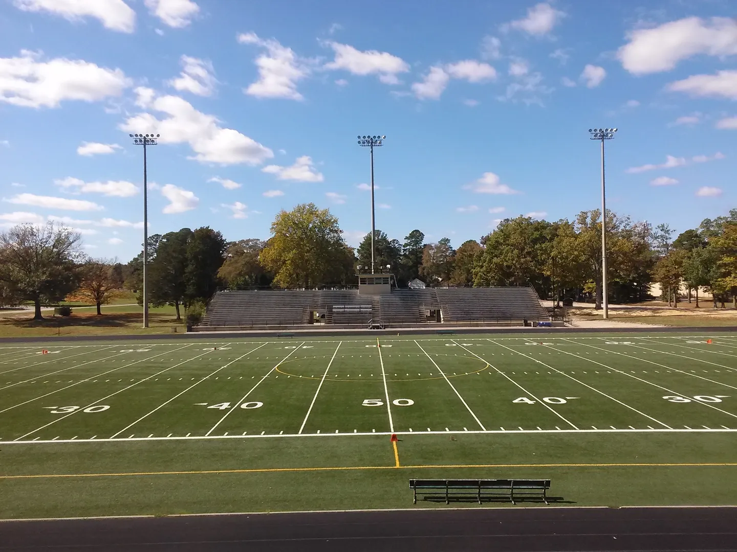 A football field with bleachers and benches.