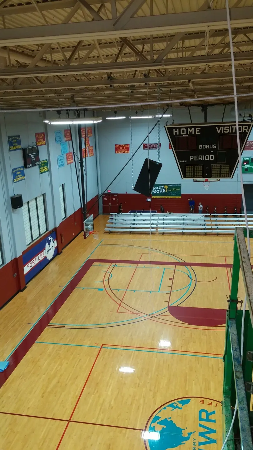 A gym with a basketball court and bleachers.